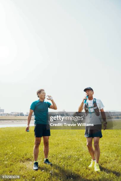 two senior men drinking water after long distance running - long distance relationship - fotografias e filmes do acervo