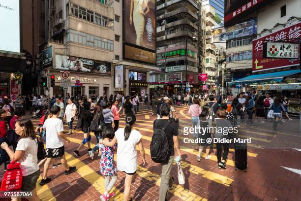 people crossing the street in the very crowded shopping district of causeway bay in hong kong island - didier marti stock pictures, royalty-free photos & images