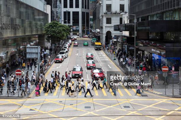 people crossing the street in hong kong central district in hong kong island, china sar - didier marti stock pictures, royalty-free photos & images