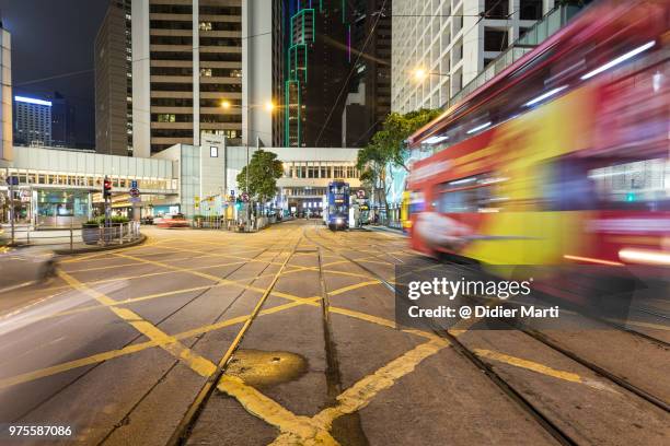 a tramway car rushing through the central intersection in the heart of hong kong - didier marti stock pictures, royalty-free photos & images