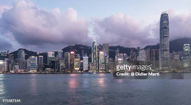 stunning sunset over the famous hong kong island skyline view from across the victoria harbor in kowloon - didier marti stock pictures, royalty-free photos & images