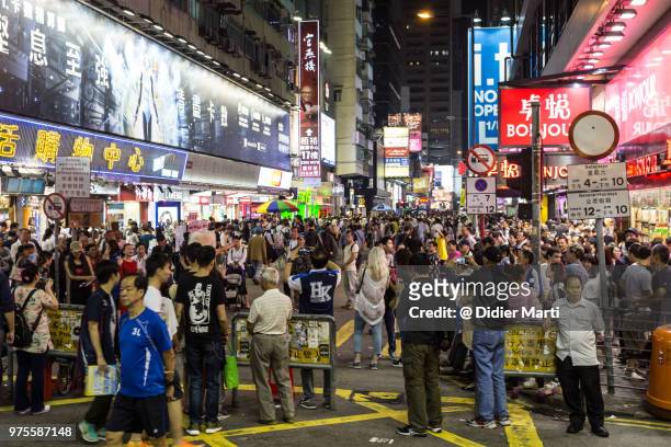 people strolling around the pedestrian area in the very crowded mong kok district in kowloon, hong kong at night - esplosione demografica foto e immagini stock