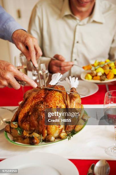 man slicing up roast turkey - table runner stock pictures, royalty-free photos & images