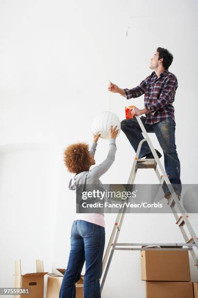 friends installing light - top of cardboard box stock pictures, royalty-free photos & images