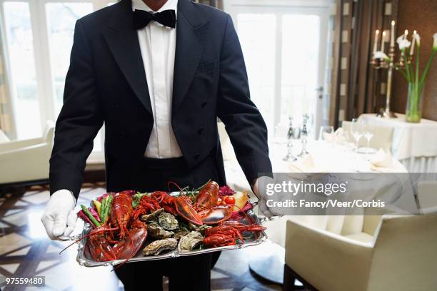 waiter carrying tray of seafood - luxury home dining table people lifestyle photography people stock pictures, royalty-free photos & images