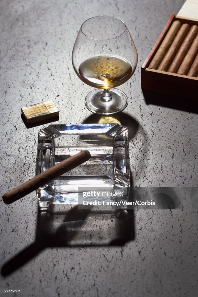 Cigar on ashtray and glass of cognac