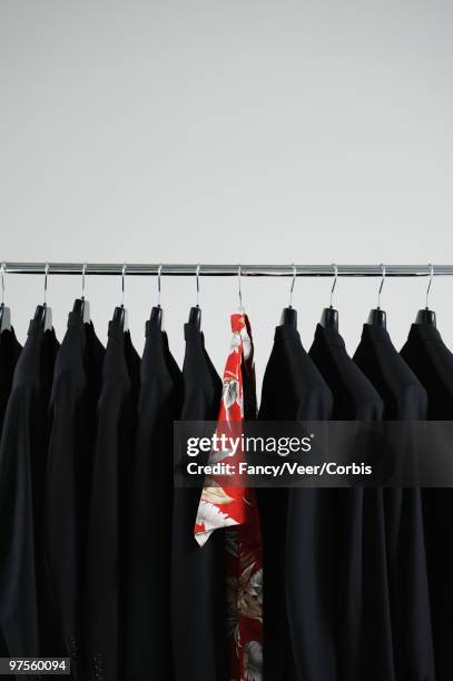 hawaiian shirt hanging between black blazers - fashion design minimalist edgy stock pictures, royalty-free photos & images