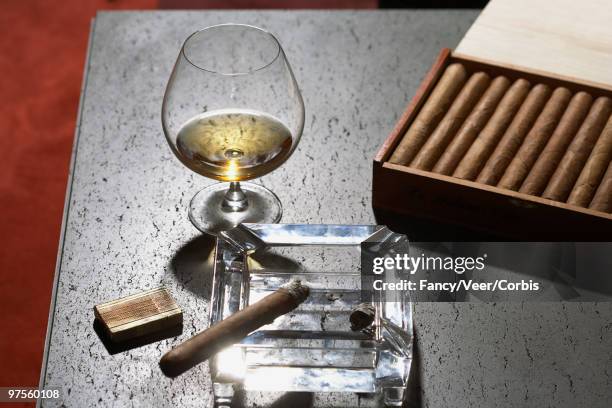 cigar on ashtray and glass of cognac - premium lighter stock pictures, royalty-free photos & images