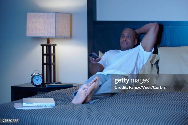 man watching tv - feet bed night stock pictures, royalty-free photos & images