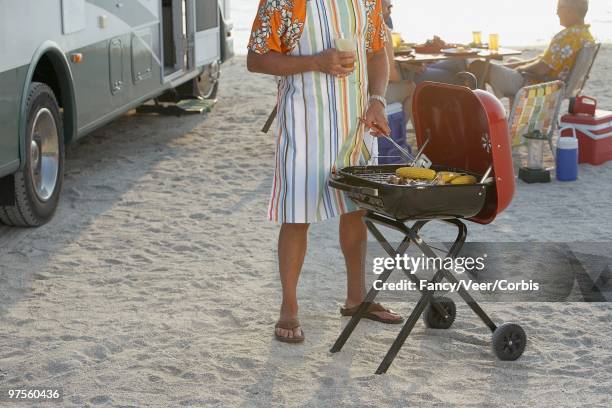 man grilling corn - insulated drink container foto e immagini stock