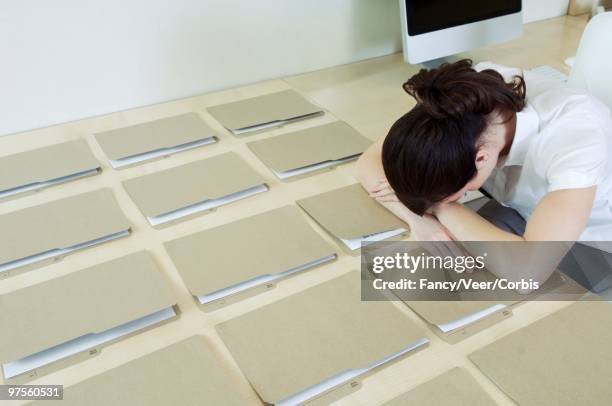 businesswoman with head down on desk - obsessive compulsive disorder organizing stock pictures, royalty-free photos & images