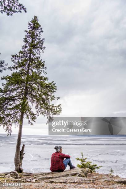 young woman enjoying, relaxing and observing the view of lake - lake shore stock pictures, royalty-free photos & images