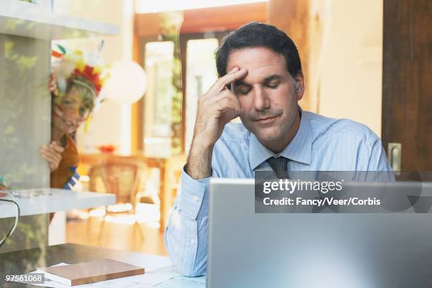 boy sneaking up on his father at laptop computer - interruptor stock pictures, royalty-free photos & images