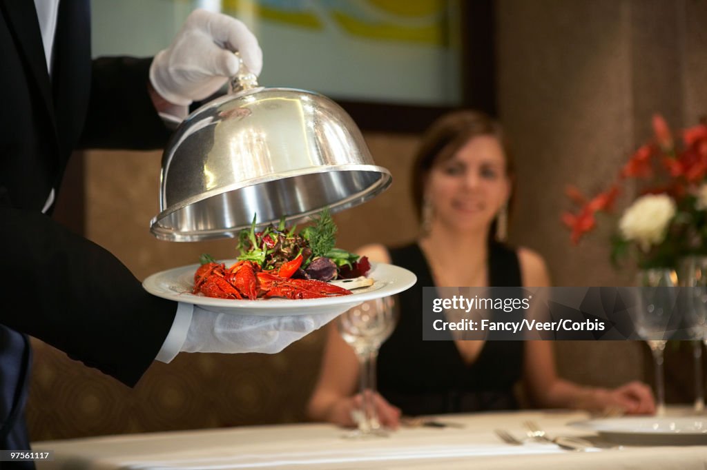 Waiter serving crayfish dinner