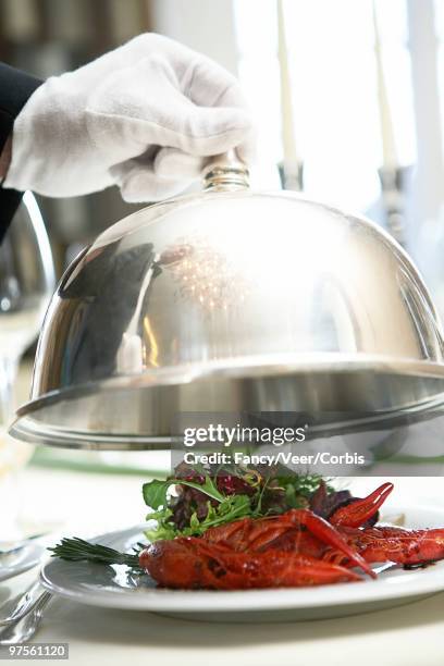 butler lifting dome from crayfish dinner - luxury home dining table people lifestyle photography people stock pictures, royalty-free photos & images