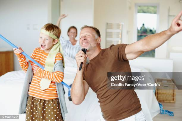 playful family - boy singing stock-fotos und bilder