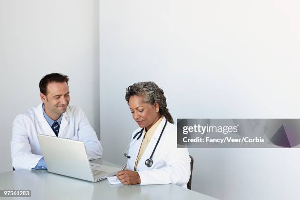 doctors working on laptop - white coat fashion item stock pictures, royalty-free photos & images