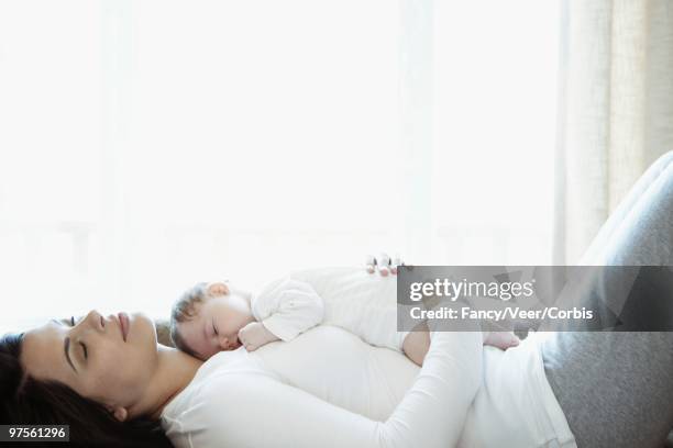 mother and baby napping - beschützer stock-fotos und bilder