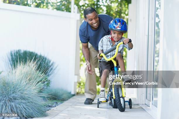 boy learning to ride bicycle - family sports centre laughing stock pictures, royalty-free photos & images