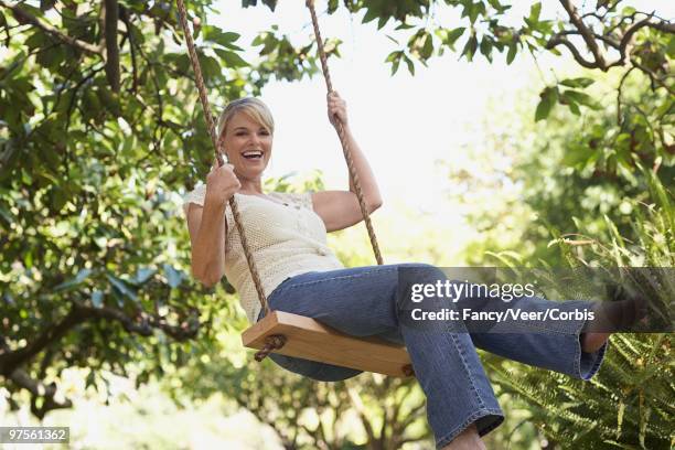 woman on a swing - woman on swing stock pictures, royalty-free photos & images