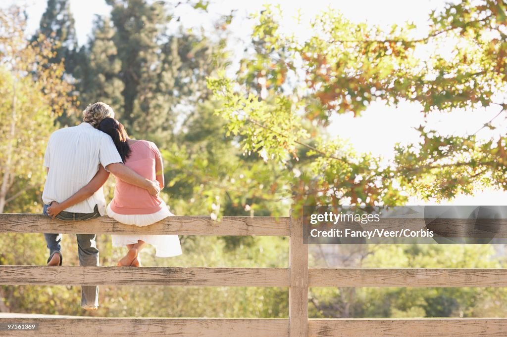 Couple Sitting Together on a Fence