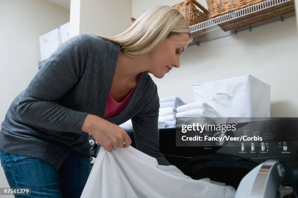 woman doing laundry - folding sheets stock pictures, royalty-free photos & images