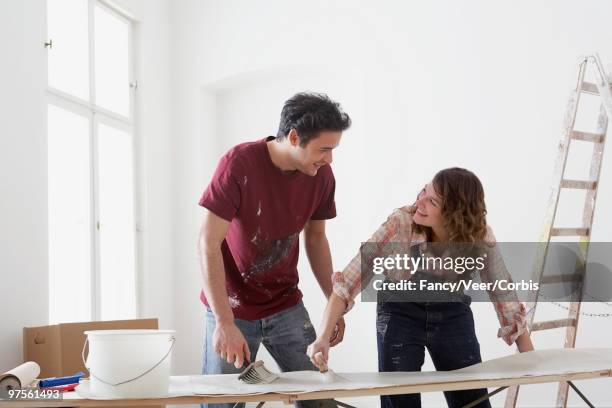 couple preparing wallpaper strip - naast stockfoto's en -beelden