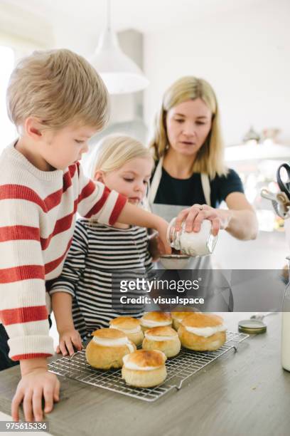 scandinavian family making semla buns using powder suger - flour sifter stock pictures, royalty-free photos & images