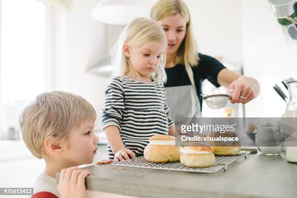 familia nórdica haciendo bollos ahí en la cocina - powdered sugar sifter fotografías e imágenes de stock