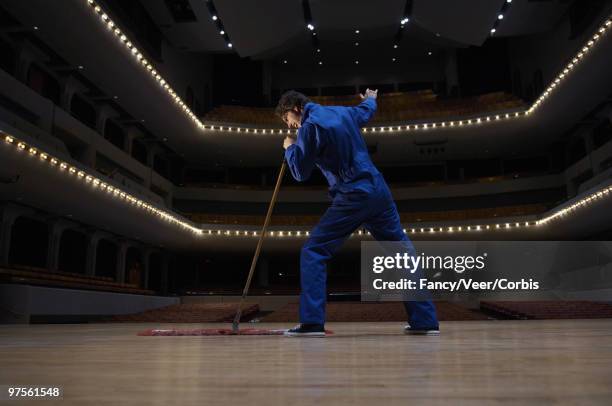 man singing in an empty theater - escoba fotografías e imágenes de stock