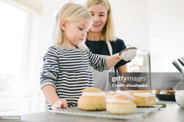 mother and daughter making sweet buns on shrove tuesday - flour sifter stock pictures, royalty-free photos & images