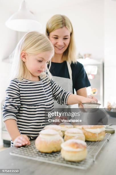 mother and daughter making sweet buns on shrove tuesday - flour sifter stock pictures, royalty-free photos & images