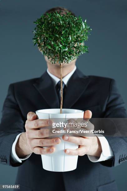 businessman holding potted plant covering his face - fashion design minimalist edgy stock pictures, royalty-free photos & images