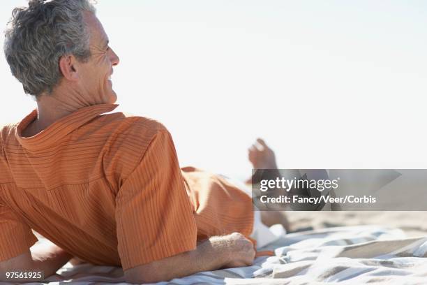 man relaxing on a beach - lying on back ストックフォトと画像