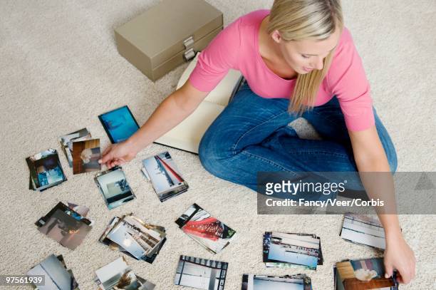 woman sorting photographs - fashion woman floor cross legged stock pictures, royalty-free photos & images
