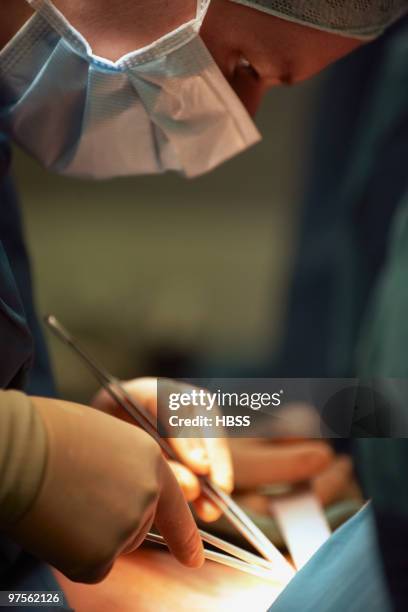 surgeon performing surgery - hemostat stock pictures, royalty-free photos & images