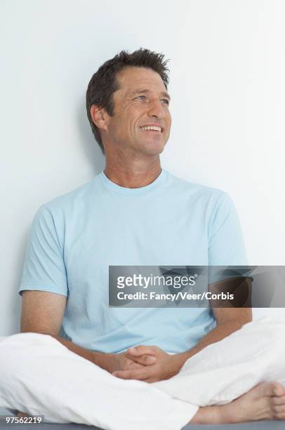 relaxed man sitting cross-legged on floor - blue eyed soul stock pictures, royalty-free photos & images