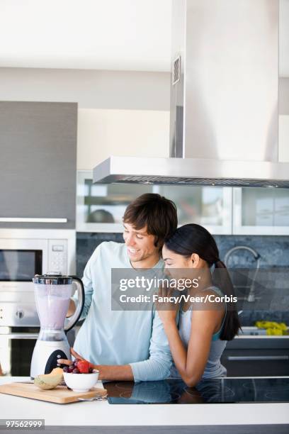 couple preparing smoothies - young urban professional person stock-fotos und bilder