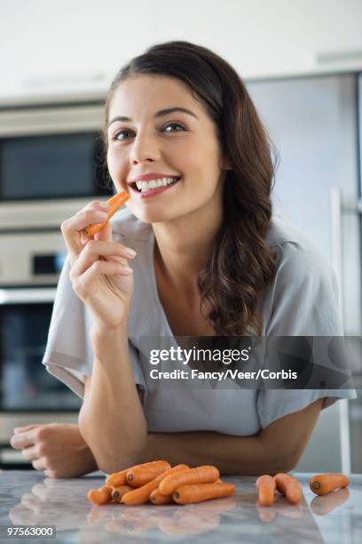 woman eating carrots - leaning on elbows stock pictures, royalty-free photos & images
