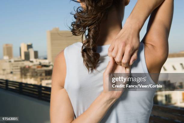 woman doing yoga on a rooftop - young urban professional person stock-fotos und bilder
