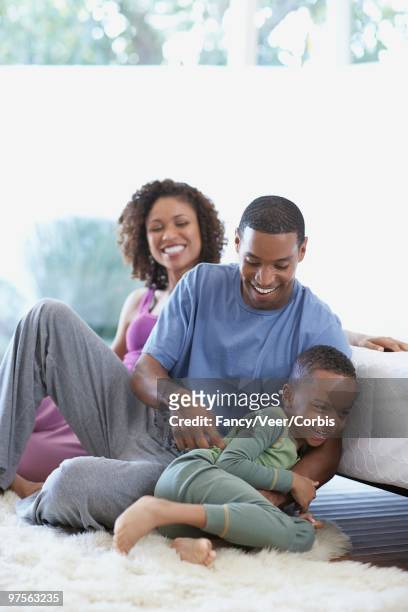 family sitting on carpet - tickling feet 個照片及圖片檔