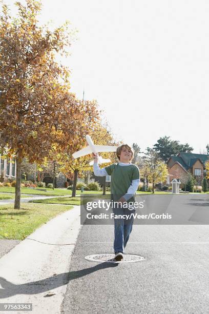 boy throwing a toy airplane - living legends of aviation stock pictures, royalty-free photos & images