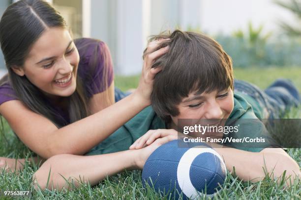 sister and brother lying on lawn - family sports centre laughing stock-fotos und bilder