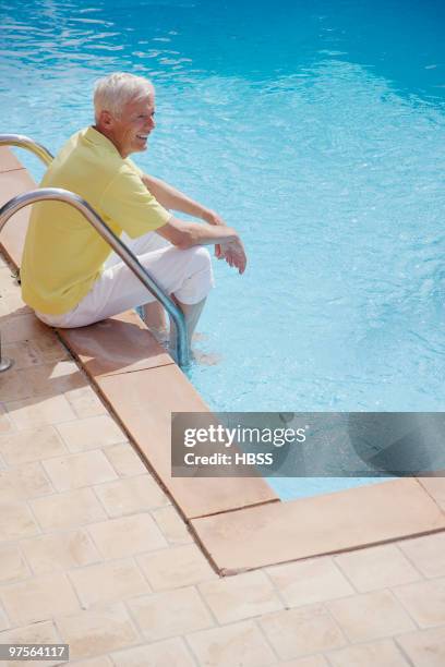 man soaking feet in swimming pool - khaki pants sitting stock pictures, royalty-free photos & images