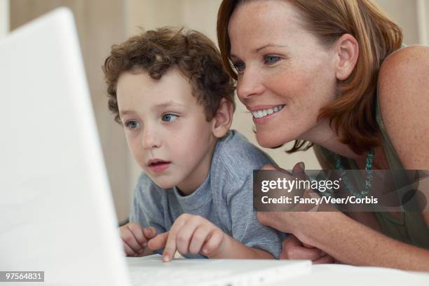 mother and son using laptop - pleased face laptop stock pictures, royalty-free photos & images