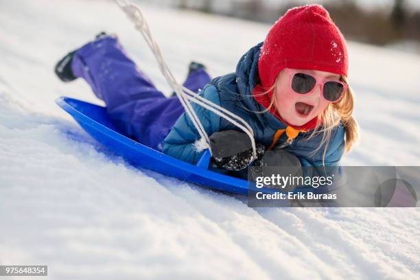 little girl being pulled on a toboggan - erik buraas stock-fotos und bilder