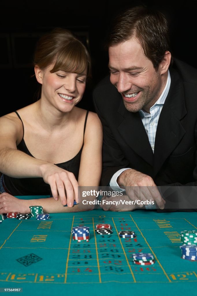 Couple placing bets on roulette game
