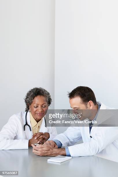 doctors looking at pda - white coat fashion item stock pictures, royalty-free photos & images