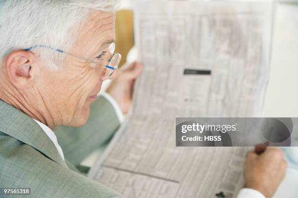 businessman reading newspaper - paper stock certificate stock pictures, royalty-free photos & images
