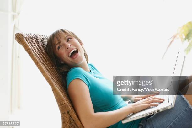 girl using laptop computer and laughing - imagem super exposta - fotografias e filmes do acervo